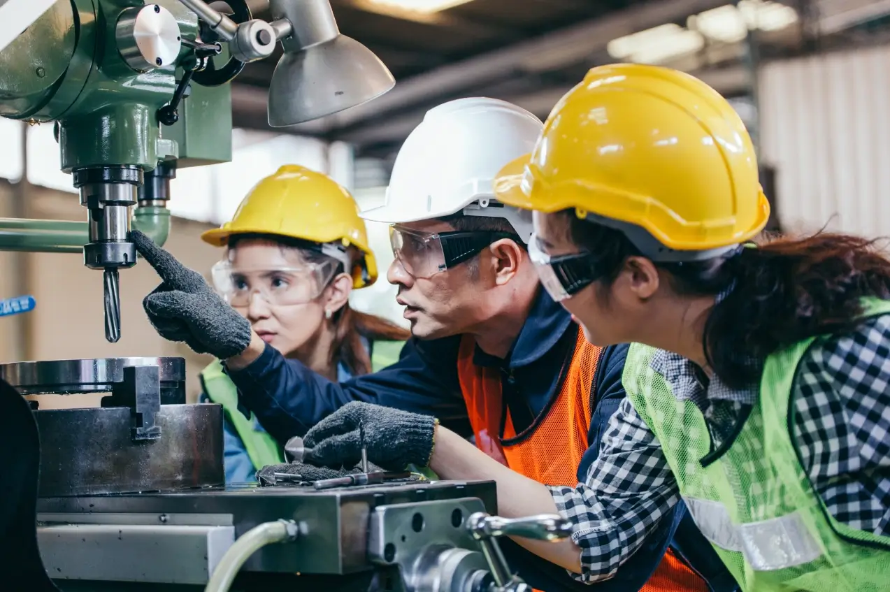 Workers operating machinery in a factory setting.